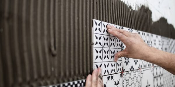 Jinshuo HEC for Tile Adhesives Professional builder applying ceramic tiles on a wall. Home building and decorating concept. Close up shot.